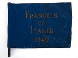 un vieux drapeau bleu avec une inscription dorée sur fond blanc