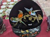 a plate with a bird design on it on a table
