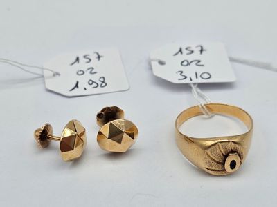 two gold rings and a pair of earrings on a white surface