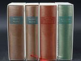 three books are lined up in a row on a black surface