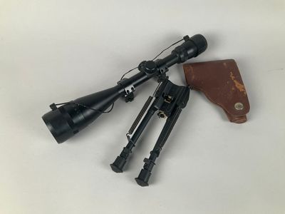 a close up of a rifle with a scope and other items
