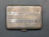 an old silver cigarette case sitting on top of a table