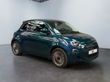 the small blue car is parked in a large room