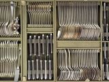 a lot of forks and spoons in a cabinet