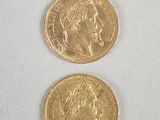 two gold coins with a man ' s face and a woman ' s face on them
