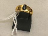 une bague en or surmontée d'une pierre noire