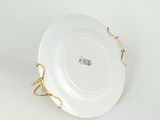 a close up of a white plate with a gold handle on a white surface
