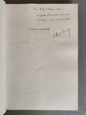 un livre ouvert sur une table, avec un stylo et de l'encre