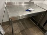 une table en acier inoxydable sur laquelle se trouve une poignée bleue