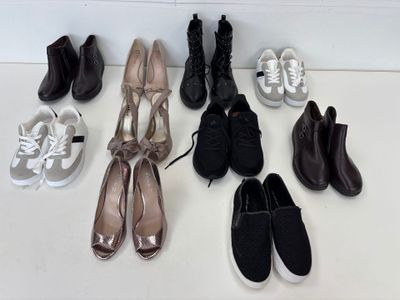 plusieurs paires de chaussures de femmes sont alignées sur une surface blanche