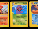 Trois cartes Pokémon sont représentées sur un fond noir ; l'une d'elles représente un ours et l'autre représente un ours.