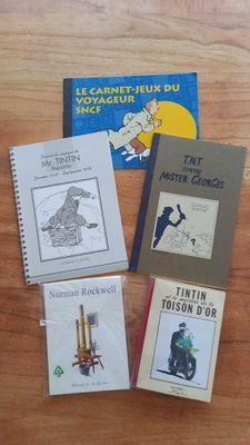 several books on a table with a wooden table in the background