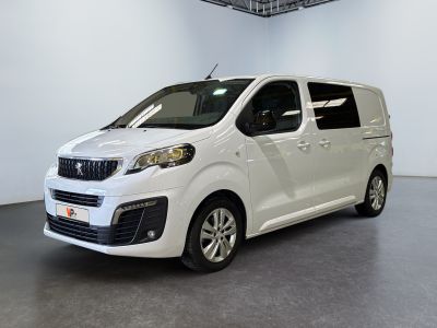 La petite camionnette blanche est garée dans une grande pièce.