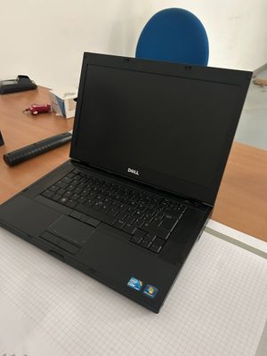 un ordinateur portable posé sur une table en bois