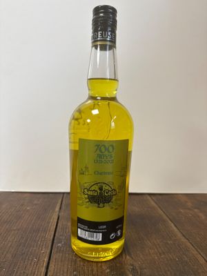 une photo d'une bouteille d'huile d'olive posée sur une table en bois