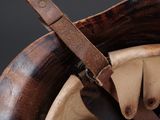 a close up of a helmet with a leather strap on it