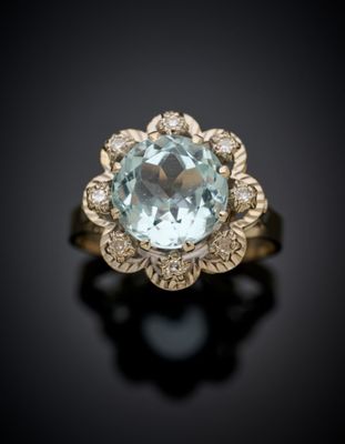 a close up of a ring with a blue topaz stone surrounded by diamonds