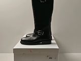 une paire de bottes noires posée sur une pile de cartons blancs