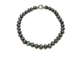 un gros plan d'un bracelet de perles noires sur fond blanc