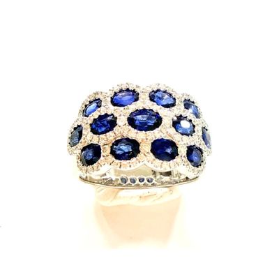 une photo d'une bague en diamant bleue et blanche posée sur une surface blanche