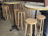 several stools and a table in a room with a bar in the background