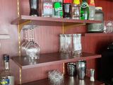 many bottles and glasses on the shelves in the room