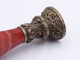 a silver and red object on a white surface