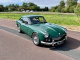 une voiture verte qui roule sur la route par une journée ensoleillée