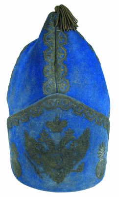 chapeau bleu et noir orné d'un oiseau sur fond blanc
