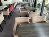 Dans un restaurant offrant une vue sur l'extérieur, les tables et les chaises sont alignées.