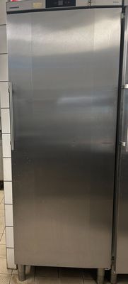 a stainless steel refrigerator in a kitchen with tile flooring