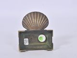 a small shell on top of a box with a green button