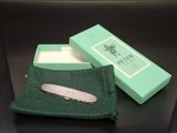 a small pocket knife in a green box on a table