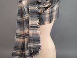 a gray and orange plaid scarf on a mannequin head