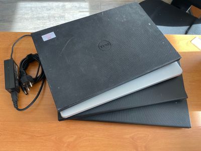 trois ordinateurs portables empilés les uns sur les autres sur une table