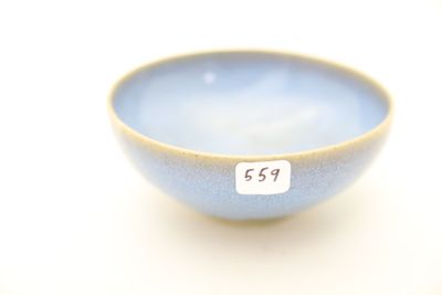 un petit bol bleu sur lequel est accrochée une étiquette blanche