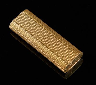 un étui à cigarettes doré posé sur une surface noire