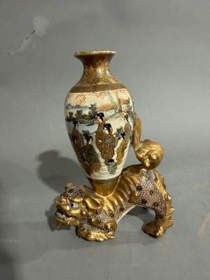 a gold vase with a dog on it on a table