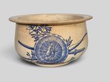 an old blue and white bowl with a bird and flowers on it