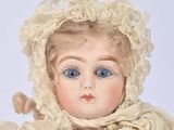 a close up of a doll wearing a bonnet and dress