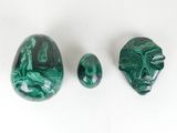 three pieces of green marble on a white surface
