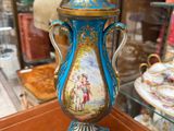a blue and gold vase sitting on top of a wooden table