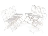 six white folding chairs with a white table and four white chairs