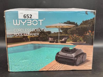 the box of a robotic pool cleaner sits on a table next to a swimming pool