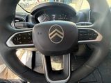 the steering wheel of a car with a phone in the center of it