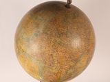 a large globe on a stand with a bird on it