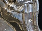 a close up of a silver plate with a bird on it