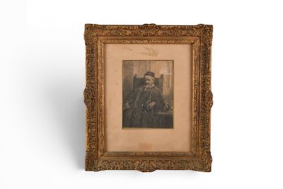 an old picture of a man in a suit and tie in a gold frame