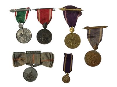 de nombreuses médailles et rubans exposés sur un fond blanc