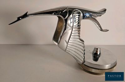 une sculpture métallique représentant un oiseau en plein vol, posée sur un socle